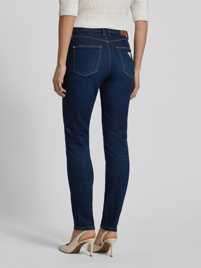 Kobiece modelka nosi Jeansy z 5 kieszeniami od Guess, mieszanka bawełny ze stretchem, krój slim fit, zapięcie na guzik, widok całej sylwetki od tyłu.