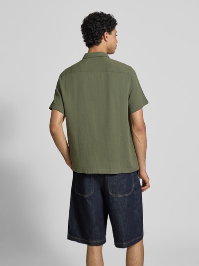 Männermodel trägt Regular Fit Freizeithemd mit Kentkragen und Brusttaschen von Superdry in Olivgrün, Strukturmuster, Rückansicht, Ganzkörperansicht Rückansicht.