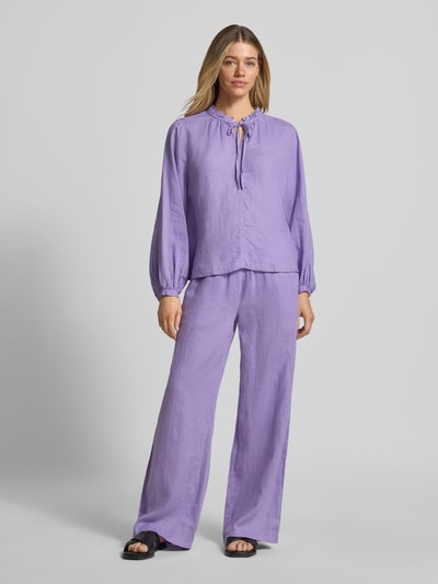 Frauenmodel trägt Leinenbluse mit Serafino-Kragen und Schnürung von Emily Van den Bergh, loose Fit, lila, Ganzkörperansicht von vorne.