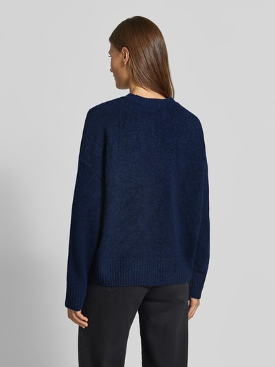 Vrouwenmodel draagt oversized pullover met wol model 'BOOM' van VERO MODA in donkerblauw met grove structuur, Dames pullover, volledig achteraanzicht.