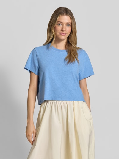 Frauenmodel trägt T-Shirt mit geripptem Rundhalsausschnitt von American Vintage in Hellblau, lockerer Schnitt, Nahaufnahme Oberkörper. Baumwoll-Modal-Mix mit Stretch-Anteil.