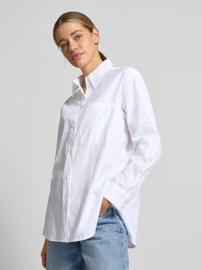 Frauenmodel trägt Oversized Hemdbluse aus reiner Baumwolle von Marc O'Polo, Optik: Unifarben, Passform: Oversized, Hemdblusenkragen, einreihige Knopfleiste, Langarm mit Manschette, Brusttasche, Materialverarbeitung: Popeline, Material: reine Baumwolle, Ganzkörperansicht von vorne.