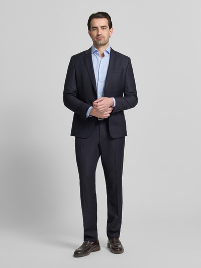 Männermodel trägt Slim Fit Businesshemd aus reiner Baumwolle Modell 'HANK' von BOSS mit feinem Streifenmuster, Ganzkörperansicht von vorne.