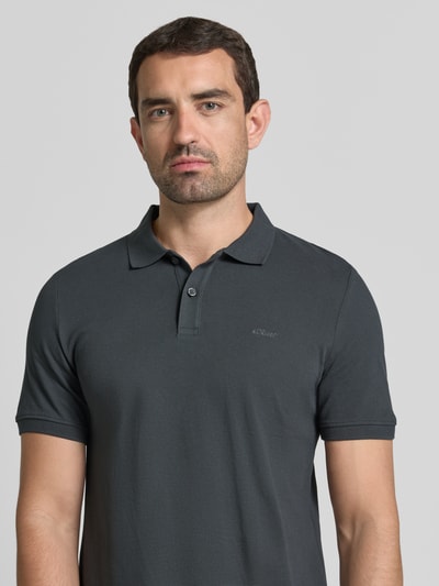 Męski model nosi Regular Fit Poloshirt aus reiner Baumwolle von s.Oliver RED LABEL, ciemnoszary kolor, jednolita faktura, zbliżenie na górną część ciała