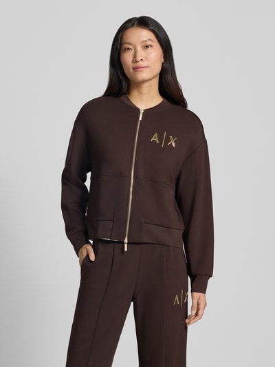 Frauenmodel trägt Sweatjacke mit Label-Print von Armani Exchange, braun mit goldfarbenem Print, Viskose-Mix, lockere Passform, Ganzkörperansicht von vorne.