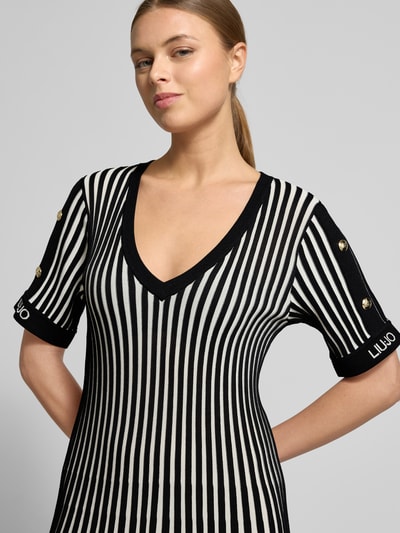 Frauenmodel trägt Minikleid mit gerippten Abschlüssen von LIU JO SPORT, schwarz-weiß gestreift, V-Ausschnitt, Nahaufnahme Oberkörper.