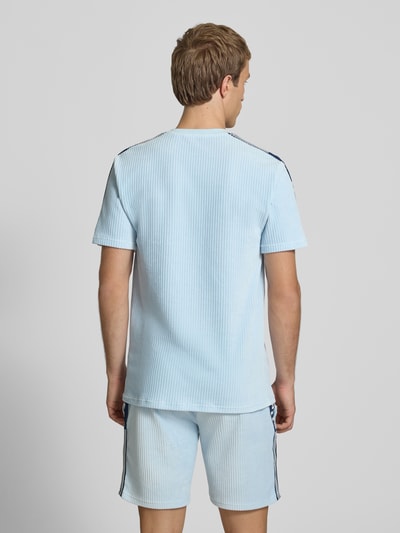 Męski model nosi T-Shirt mit Logo Modell 'MADORI' od Ellesse, mieszanka bawełny, krój regular fit, okrągły dekolt, długość tyłu w rozmiarze M: 66 cm, jasnoniebieski, faktura prążkowana, widok całej sylwetki z tyłu.