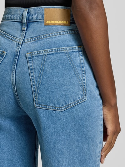 Frauenmodel trägt Loose-Fit Jeans aus reiner Baumwolle Modell 'ENIJAA' von Armedangels in Denim-Optik mit Label-Patch, Detailaufnahme.