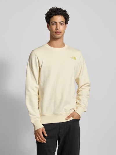 Männermodel trägt Sweatshirt mit Label-Print von The North Face in Creme, Reine Baumwolle, Regular-Fit, Gerippte-Abschlüsse, Rundhalsausschnitt, Nahaufnahme Oberkörper.