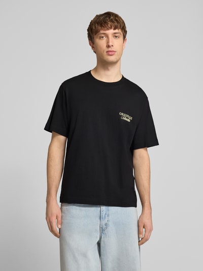 Männermodel trägt Herren T-Shirt mit Statement-Print Modell 'NORREBRO' von Jack & Jones in Schwarz aus Reine Baumwolle, gerader Schnitt, Rundhalsausschnitt, Ganzkörperansicht von vorne.