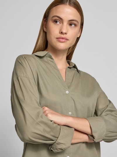 Frauenmodel trägt Langarmbluse mit Lyocell-Anteil von Juvia in Khaki, Baumwoll-Lyocell-Mix, sichtbare Knopfleiste, Nahaufnahme Oberkörper.