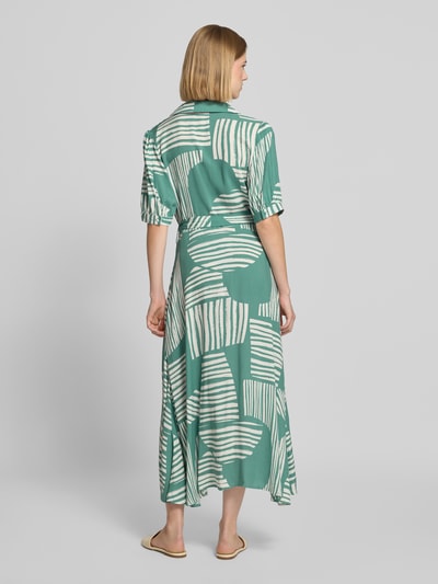 Frauenmodel trägt Midikleid aus reiner Viskose Modell 'Azura' von ZABAIONE mit grün-weißem Muster, taillierter Passform, Ganzkörperansicht Rückansicht.
