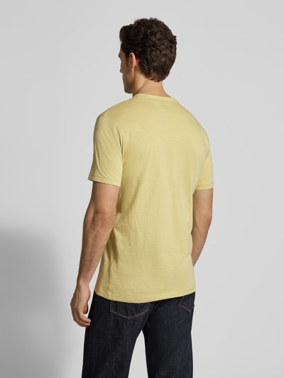 Männermodel trägt Regular Fit T-Shirt aus strukturierter Baumwolle Modell 'TEGOOD' von BOSS Orange in hellgelb, unifarben, reine Baumwolle, Ganzkörperansicht Rückansicht.