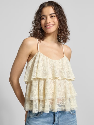 Frauenmodel trägt Regular Fit mit floralem Allover-Spitzenbesatz von Gina Tricot aus elastischem Material-Mix mit Rüschenbesatz und Spaghettiträgern, cremefarbene Spitze, Ganzkörperansicht von vorne.