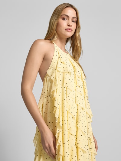 Frauenmodel trägt Cocktailkleid mit Neckholder Modell 'FINILLO' von YAS aus Chiffon, Volants, hellgelbe Farbe mit Punkten, Nahaufnahme Oberkörper. Rückenlänge Größe 36: 110 cm, Brustweite: 40 cm, Straight Fit, Maxikleid.