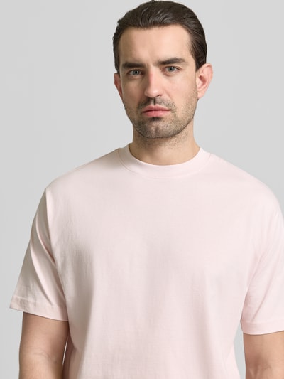 Männermodel trägt Regular Fit T-Shirt aus reiner Baumwolle von MCNEAL in zartem Rosa, Rundhals, kurzärmelig, Nahaufnahme Oberkörper.