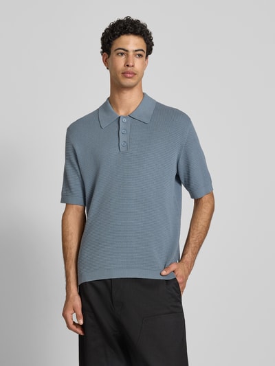 Mannelijk model draagt Regular Fit poloshirt uit puur katoen van Marc O'Polo Denim in effen kleuren, knitwear, labelpatch, korte mouw, polokraag, v-hals, korte knoopsluiting, geribde rompzoom en mouwboord, voorkant volledig in beeld.