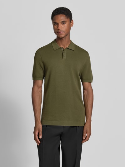 Męski model nosi Slim Fit Poloshirt mit kurzer Knopfleiste Modell 'TRITON' von Drykorn z czystej bawełny, krój slim fit, kolor oliwkowy, przód, ujęcie całej sylwetki.