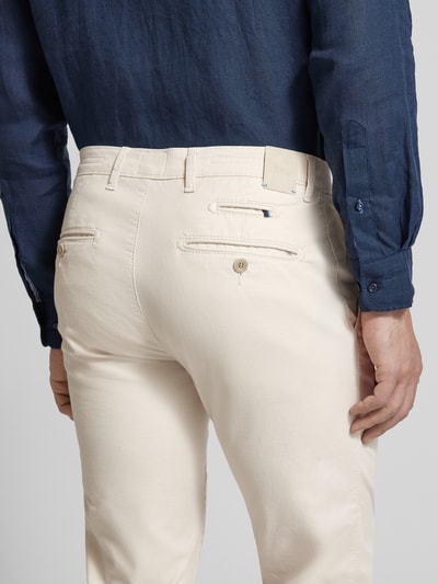 Männermodel trägt Slim Fit Stoffhose mit Gesäßtaschen Modell 'Fabio' von BRAX, katoenmix, muntzakje, knoop- en ritssluiting, ganzkörperansicht rückansicht. Bandwijdte 44 cm, binnenbeenlengte 81 cm.