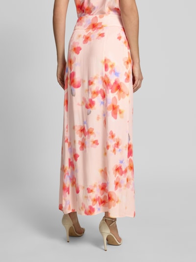 Vrouwenmodel draagt Maxirock aus Viskose Modell 'Zephyra' van mbyM, A-lijn, all-over print, zachte kleuren, pure viscose, achteraanzicht hele lichaam.