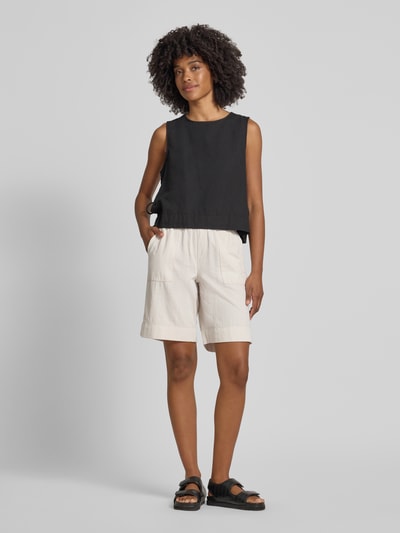 Frauenmodel trägt Bermudas mit elastischem Bund und Kordelzug Modell 'Lia Urban' von Angels aus Reine Baumwolle, Loose-Fit, sandfarbene Struktur, mit Seitliche Eingrifftaschen und Gesäßleistentaschen, Ganzkörperansicht von vorne.