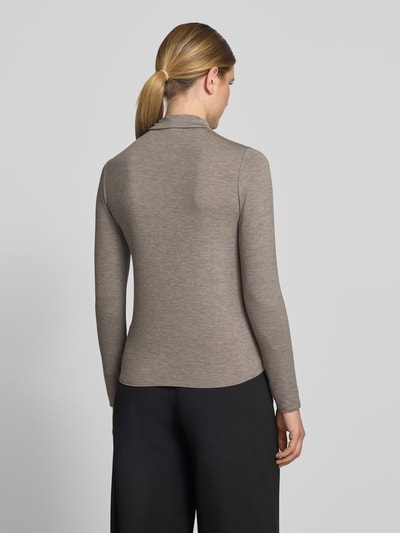 Frauenmodel trägt Longsleeve mit Rollkragen von someday, beigefarbener Viskose-Mix mit Ripp-Struktur, eng anliegend, Ganzkörperansicht Rückansicht.