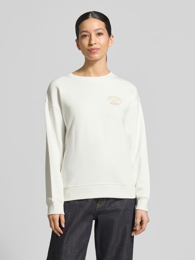 Frauenmodel trägt Sweatshirt mit Label-Stitching und Rundhalsausschnitt von Gant aus weißer Baumwolle im Loose Fit, gerippte Bündchen, Ganzkörperansicht von vorne.