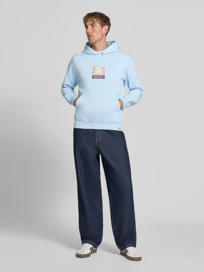 Männermodel trägt Hoodie mit Label-Print Modell 'FREDERIKSBERG' von JACK & JONES in Hellblau, Baumwoll-Mix, lockerer Schnitt, Ganzkörperansicht von vorne.