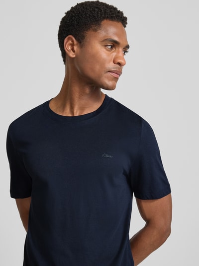 Męskimodel nosi Regular Fit T-Shirt aus reiner Baumwolle von s.Oliver RED LABEL w ciemnogranatowym kolorze, gładka faktura, zbliżenie na górną część ciała