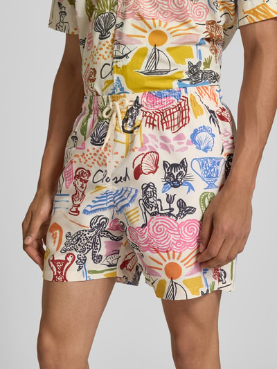 Männermodel trägt Badehose mit elastischem Bund von Closed, bunte Muster, Eingrifftaschen, Tunnelzug, Nahaufnahme Oberkörper.