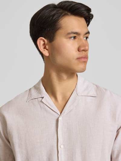 Männermodel trägt Regular Fit Freizeithemd aus Baumwoll-Leinen-Mix von Jack & Jones in Beige mit Reverskragen, Knopfleiste, Nahaufnahme Oberkörper.