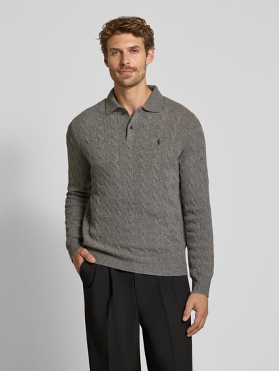 Männermodel trägt Regular Fit Pullover aus Woll-Kaschmir-Mix von Polo Ralph Lauren in Grau, Zopfstrick, Ganzkörperansicht von vorne.