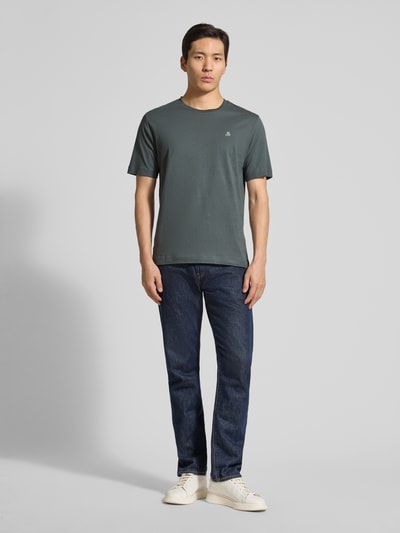Männermodel trägt Regular Fit T-Shirt aus reiner Baumwolle von Marc O'Polo in Unifarbe mit Logo-Stitching, Ganzkörperansicht von vorne.