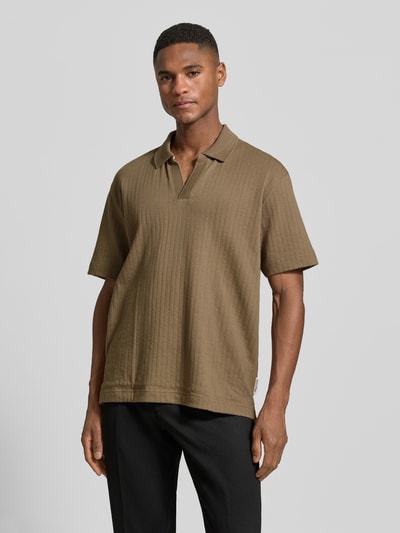 Männermodel trägt Relaxed Fit Poloshirt aus reiner Baumwolle von Marc O'Polo in Braun, unifarben, strukturierte Webstruktur, Nahaufnahme Oberkörper.