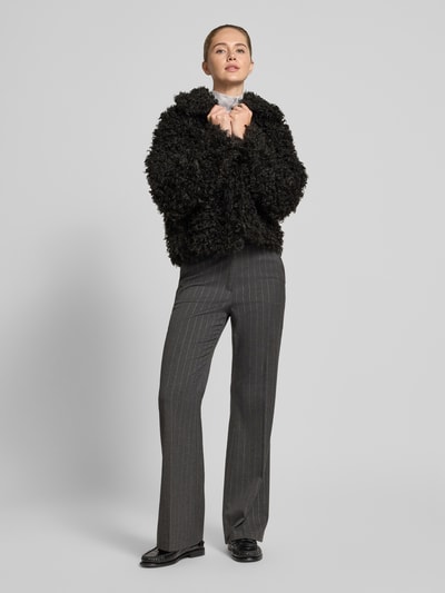 Frauenmodel trägt schwarze Felljacke in cropped-Fit - curated by Isabelle Hartmann von Style Icon Collection, Regular Fit, Kunstfell, Reißverschluss, kombiniert mit grauer Hose; Ganzkörperansicht von vorne.