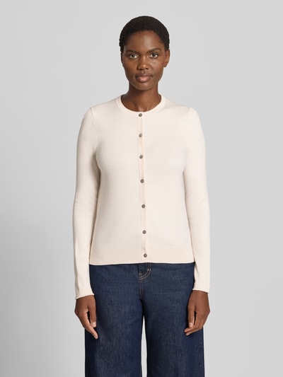 Vrouwenmodel draagt Regular Fit gebreid jack uit viscosemix met geschulpte zoom van Christian Berg Woman, lange mouw, knoopsluiting, ribboorden, ruglengte maat S 56 cm, mouwlengte maat S 61 cm, effen lichtbeige, gladde textuur, volledige lichaamsaanzicht vooraan.