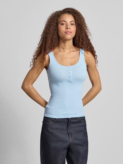 Frauenmodel trägt Slim Fit Tank Top aus Bio-Baumwoll-Mix Modell 'KITTE' von Pieces, Optik: Unifarben, Knopf-Detail, Henley-Ausschnitt, breite Träger, Materialverarbeitung: Ripp, Ganzkörperansicht von vorne.