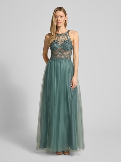 Frauenmodel trägt Regular Fit Abendkleid in semitransparentem Design von Laona mit floralem Spitzenbesatz, Ziersteinbesatz und Halterneck, Mesh und blickdichtem Unterrock in Grün, Ganzkörperansicht von vorne.