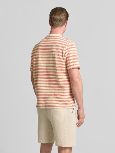 Männermodel trägt Regular Fit T-Shirt aus Baumwoll-Mix Modell 'ELI' von Selected Homme mit roten und beigen Streifen, Ganzkörperansicht Rückansicht. Herren T-Shirt
