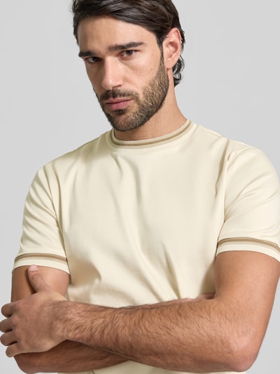 Männermodel trägt Slim Fit T-Shirt aus reiner Baumwolle Modell 'TESSLER 202' von BOSS in Unifarbe, Nahaufnahme Oberkörper.