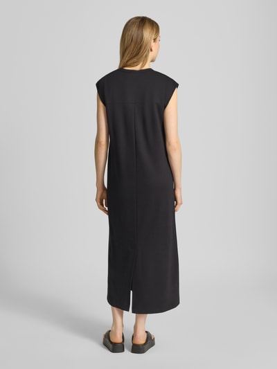 Frauenmodel trägt Relaxed Fit Midikleid aus Viskose-Mix Modell 'Seano' von B.Young in Schwarz, strukturierte Oberfläche, Ganzkörperansicht Rückansicht.