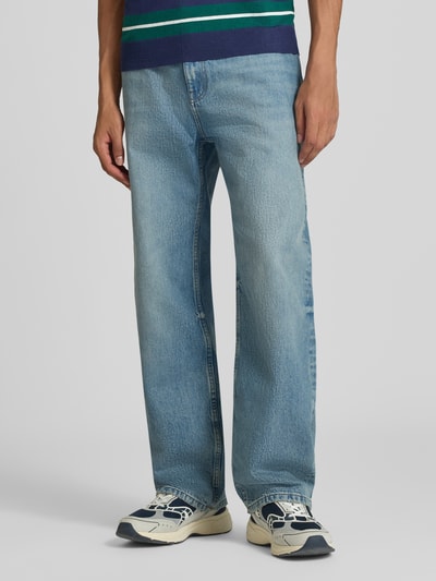 Männermodel trägt Baggy Fit Jeans mit Knopfverschluss von REVIEW, reine Baumwolle, hellblaue Waschung, 5-Pocket-Design, Ganzkörperansicht von vorne.