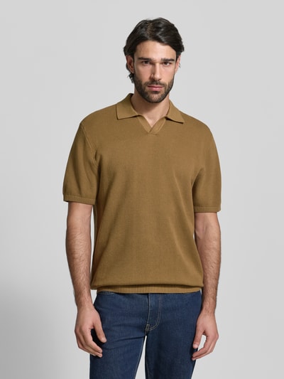 Männermodel trägt Regular Fit Poloshirt mit gerippten Abschlüssen von MCNEAL aus bawełna, kołnierzyk polo, prążkowane wykończenia, długość tyłu 71 cm, długość rękawów 30 cm, krój regular fit, kolor brązowy, gładka faktura, całkowity widok z przodu