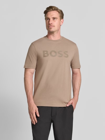 Męski model prezentuje t-shirt krój regular fit z czystej bawełny, model 'TS_STRUCTURE LOGO 1027473' od BOSS Green, kolor beżowy, matowa faktura, widok całej sylwetki z przodu.