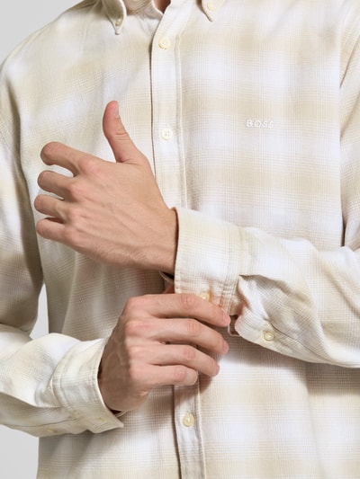 Männermodel trägt Relaxed Fit Freizeithemd aus reiner Baumwolle Modell 'CODY' von BOSS in Beige mit feiner Karostruktur, Nahaufnahme Oberkörper, Herren Freizeithemd von BOSS