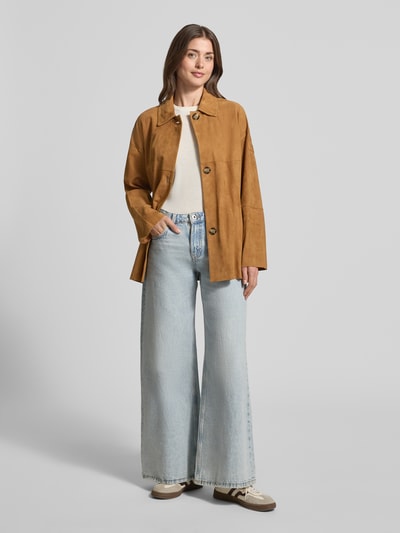 Frauenmodel trägt Jacke in Suede-Optik Modell 'Machuca' von Peuterey in Camel, matt, mit Umlegekragen, Knopfleiste, Ganzkörperansicht von vorne. Taillierte Passform, abnehmbares Taillenband, Damenjacke, strukturierte Oberfläche.