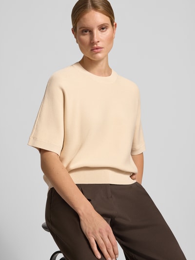 Frauenmodel trägt Relaxed Fit Pullover aus Viskose-Mix Modell 'Thamira' von MSCH Copenhagen in Beige, Strick-Optik, Nahaufnahme Oberkörper.