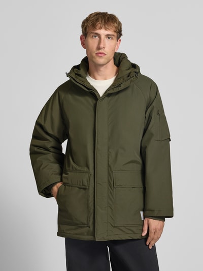 Männermodel trägt olivgrünen Parka mit Pattentaschen Modell 'Stanwood' von Carhartt Work In Progress, Regular Fit, Ganzkörperansicht von vorne.