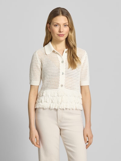 Frauenmodel trägt Strickshirt mit Fransen von Christian Berg Woman Selection aus cremeweißem Baumwoll-Mix, Umlegekragen, Knopfleiste, 1/2-Arm, Ganzkörperansicht von vorne.