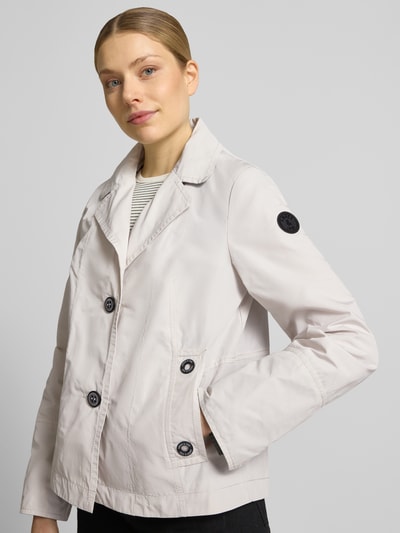 Modelka kobieca nosi Jacke im 2-in-1-Look od Amber & June, krój regular fit, klapy z rewersami, beżowy kolor, tekstura gładka, detal z logo, szerokość w rozmiarze 36: 51 cm, długość tyłu w rozmiarze 36: 65 cm, szerokość ramion w rozmiarze 36: 42 cm, długość rękawa w rozmiarze 36: 63 cm, widok na cały korpus od przodu